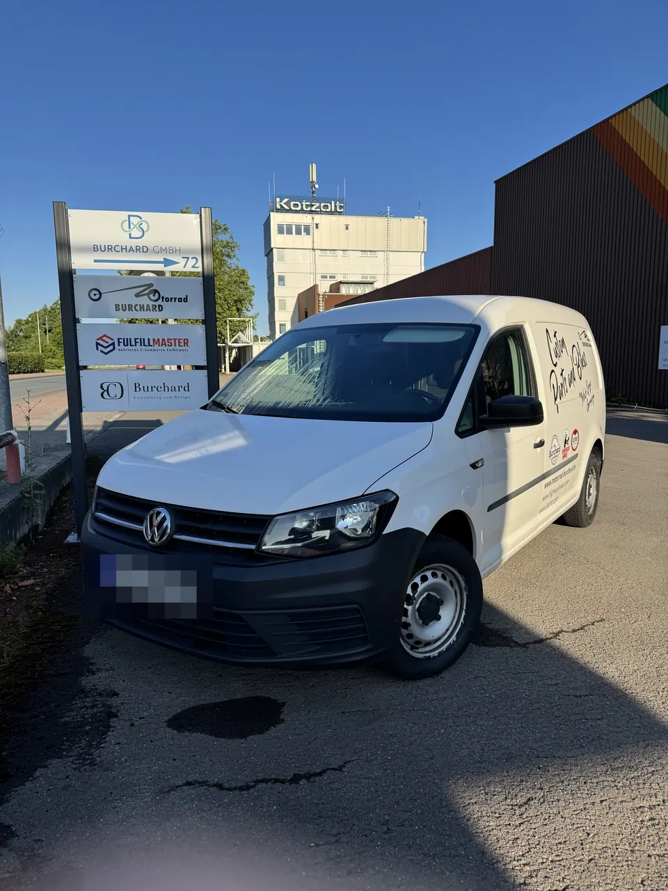 Einfahrt zur Burchard GmbH mit Wegweiser und Firmenwagen