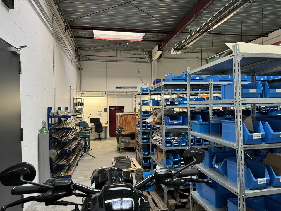 Arbeitsplatz in der Motorradwerkstatt mit Motorrad und Teilelager